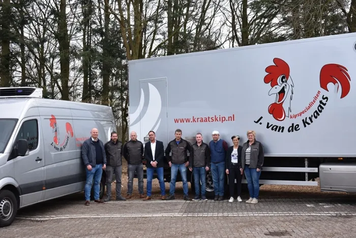 Photo of the J. van de Kraats team with two company vehicles in the background