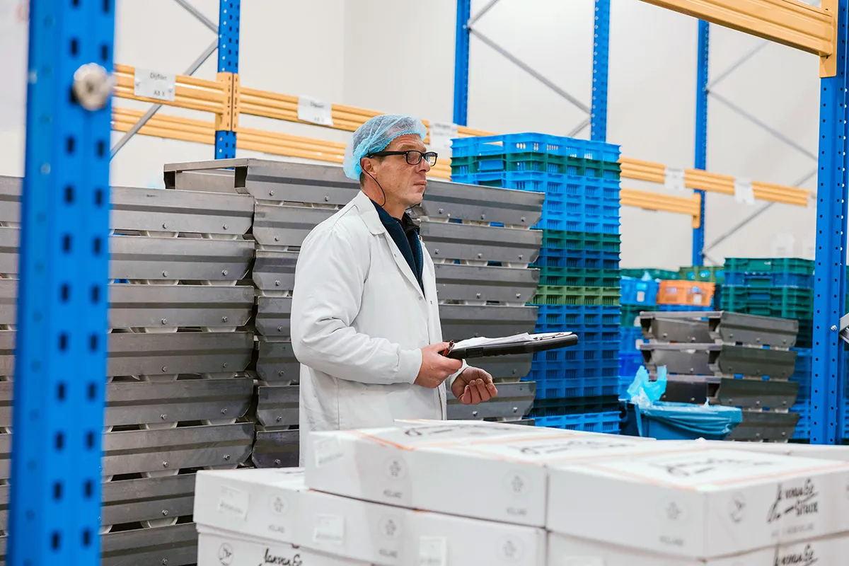 Medewerker met bril in expeditieruimte kipverwerkingsbedrijf